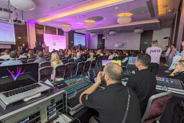 Conference room at Hilton Tower Bridge London with stage, screens and guest seating